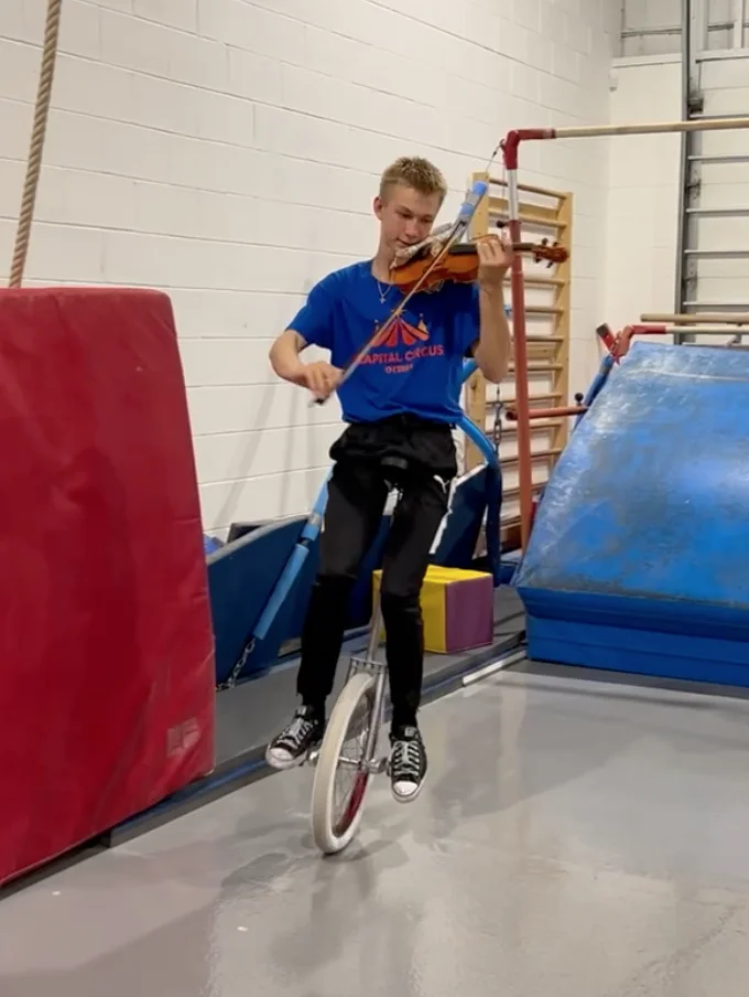 Kids balancing on unicycles and practicing jumping skills in Ottawa circus program.