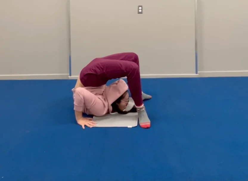 A person deepening a yoga pose with the skills learned from contortion training, demonstrating improved flexibility and control.